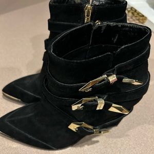 Vince Camino black bootie with gold toe edging and buckles. Leather